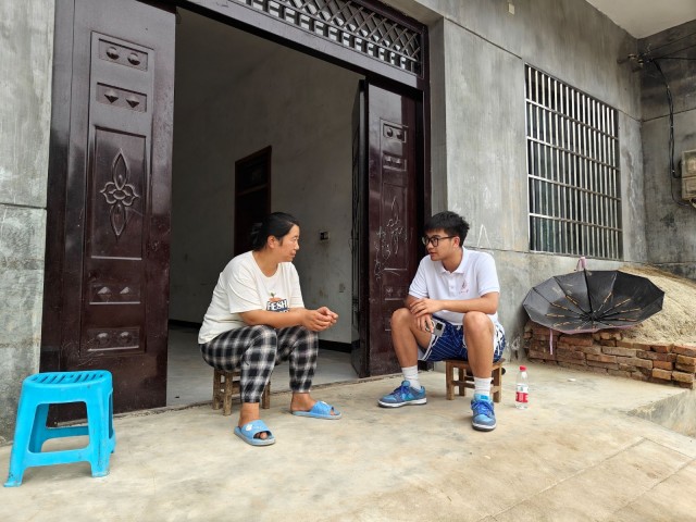 图为支教团成员正在与家长了解学生在家的学习情况。李时充 供图.jpg
